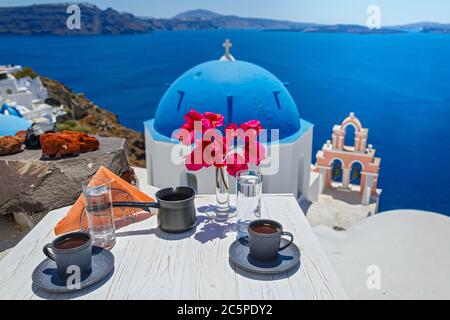 Kaffee am Morgen vor der Kulisse des Meeres und der Architektur der Insel Santorini Stockfoto