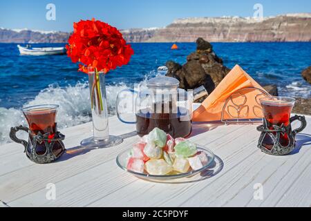 Tee und Süßigkeiten am Strand vor dem Hintergrund der Meereswelle Stockfoto