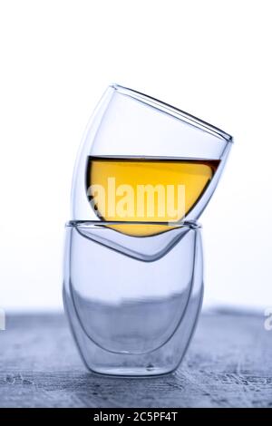 Espressotassen aus doppeltem Glas auf schwarzem Hintergrund mit Tee Stockfoto