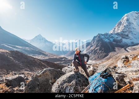 Junge Wandererin Backpacker lächelnd und posiert auf der Everest Base Camp Route am Everest Memorial, Chukpi Lhara, Nepal. AMA Dablam Berg 6812m auf Bac Stockfoto