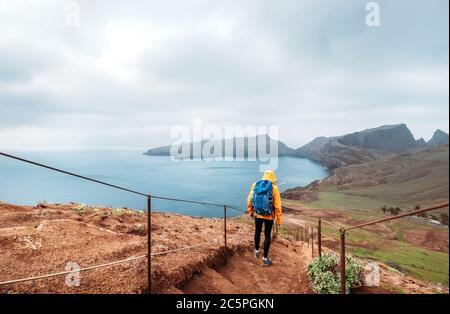 Junge männliche Backpacker wandern auf dem Wanderweg auf Sao Lourenco Landzunge mit Blick auf den Atlantik Bucht Ende Februar, Madeira Insel, Portugal. Aktiv Stockfoto