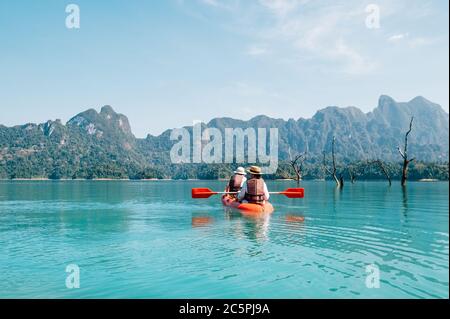 Mutter und Sohn schweben gemeinsam auf dem Cheow Lan See in Thailand auf dem Kajak. Reisen mit Kindern Konzept Bild. Stockfoto