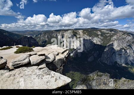 Ein Wanderer bewundert den Blick auf das Yosemite Valley vom Taft Point entlang des Pohono Trail. El Capitan und der Merced Fluss im Tal sichtbar. Stockfoto