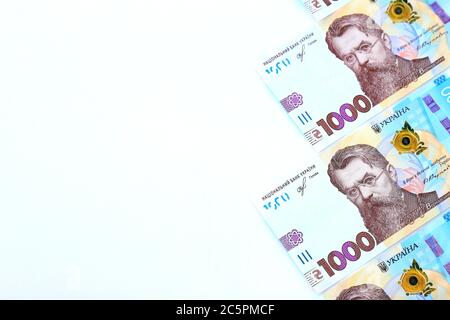 Ukrainische Griwna, neue Banknoten von 1000 Griwna auf weißem Hintergrund, diagonale Position, Nahaufnahme, isoliert. Geldhintergrund, Konzept der Geschenke Stockfoto