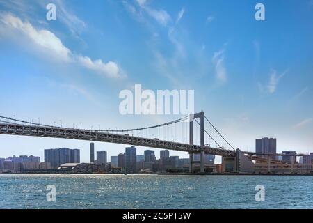 tokio, japan - april 04 2020: Zweischichtige Regenbogenbrücke in der Bucht von Tokio mit den Wolkenkratzern des Shinagawa-Viertels im Hintergrund. Stockfoto