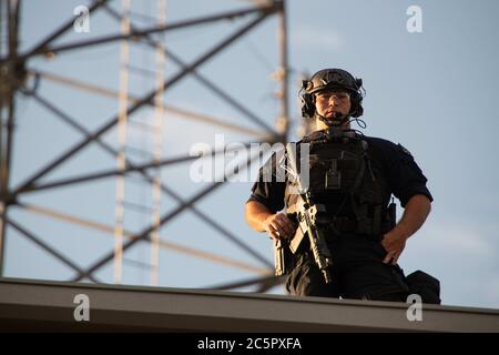 Aurora, Colorado, USA. Juli 2020. Als Demonstranten das Gebiet um die Aurora Polizeistation besetzten, überwachten die Polizisten die Menge vom Dach des Bezirks aus. Quelle: Tyler Tomasello/ZUMA Wire/Alamy Live News Stockfoto