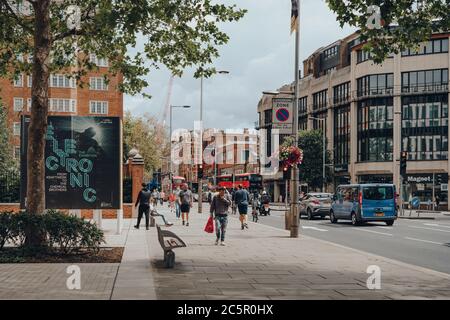 London, Großbritannien - 20. Juni 2020: Menschen und Autos auf der High Street Kensington, der Haupteinkaufsstraße in Kensington, London. Stockfoto