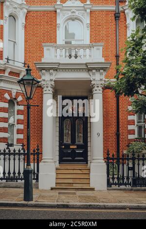 London, Großbritannien - 20. Juni 2020: Eingang eines traditionellen Hauses mit einem stoop in Kensington, einer wohlhabenden Gegend von West London, die von Prominenten bevorzugt wird. Auswahl Stockfoto