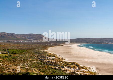 Noordhoek Beach entlang der Kap-Halbinsel Südafrikas, mit einem klaren blauen Himmel über dem Meer Stockfoto