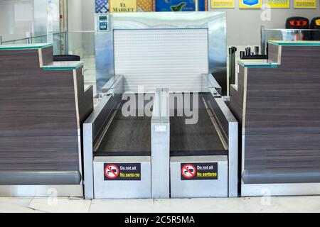 Leere, ungenutzte Check-in-Schalter, Gepäckabgabeschürtel am Flughafen Teneriffa Süd, Abflugbereich, aufgrund von Reisebeschränkungen für den Ausbruch des Coronavirus Covid-19. Stockfoto