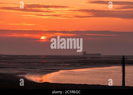 Blick auf das Meer von Fleetwood an der Küste von Lancashire mit einem Schiff, das bei Sonnenuntergang in der irischen See vorbeifährt Stockfoto