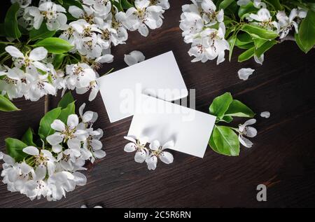 Leere Visitenkarten und Blumen auf Holzhintergrund. Großer Mockup. Flach liegend. Stockfoto