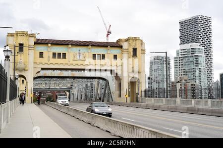 Der Verkehr bewegt sich über die Burrard Street Brücke neben einer geschützten Fahrradstraße und einem Bürgersteig in Vancouver, British Columbia, Kanada. Neue Wohnanlage Stockfoto