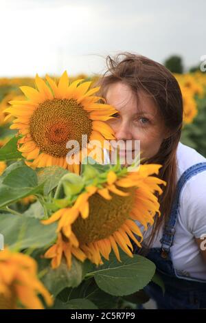 Schönes Mädchen in einem Feld mit Sonnenblumen. Stockfoto