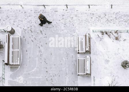 Mann, der auf verschneiten Gehwegen läuft, Blick von oben Stockfoto