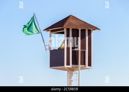 Ein Rettungsschwimmer auf dem Wachturm. Roter hölzerner Rettungsschwimmer Turm Stockfoto