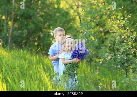 Kleiner Junge umarmt ein Mädchen auf die Natur im Sommer Stockfoto