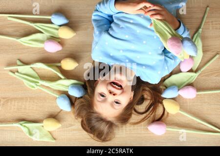 Schönes Mädchen liegt auf dem Boden unter handgefertigten Blumen Stockfoto