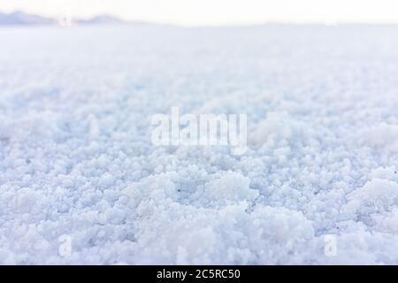 Nahaufnahme Makro-Low-Angle-Bodenansicht der Textur von Bonneville Salzebenen mit nassem Salz auf dem Boden abstrakt mit Horizont im Hintergrund Stockfoto