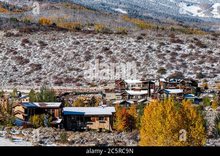 Aspen, Colorado felsige Berge mit Häusern, die nach dem Winter mit gelben Herbstbäumen und Stadtbild bedeckt sind, moderne Skiresort-Lodge-Stadt Stockfoto