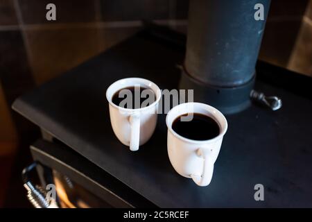 Nahaufnahme von zwei Tassen mit schwarzem Kaffee oder puerh Tee auf Retro-Kamin rustikalen Vintage-Landhaus am Morgen Stockfoto