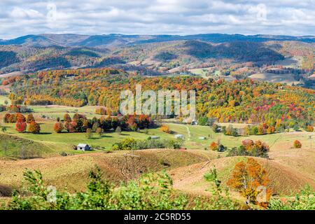 Herbst rot orange bunte Ahornbäume und Bauernhof Haus Land rollende Hügel Luft über Hochwinkel-Ansicht Landschaft in Blue Grass, Highland County, V Stockfoto