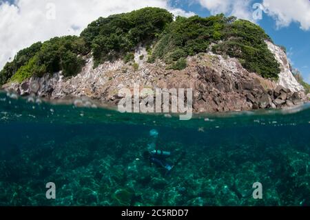 Taucher und Insel Split Shot, Red Cliff Tauchplatz, Manuk Island, Indonesien, Banda Sea Stockfoto