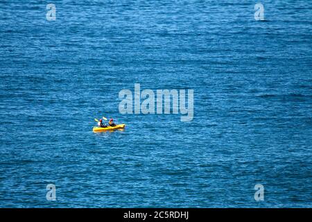 Zwei Personen tragen rote Helme in Yellow Sea Kayak Stockfoto