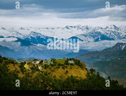 Ein malerisches Dorf im Hintergrund der schneebedeckten Himalaya-Berge im Winter. Himachal Pradesh, Indien. Stockfoto