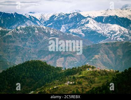 Ein malerisches Dorf im Hintergrund der schneebedeckten Himalaya-Berge im Winter. Himachal Pradesh, Indien. Stockfoto