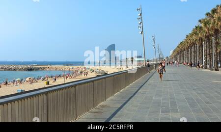 BARCELONA, SPANIEN - 12. JULI 2015: Blick auf den Barceloneta Strand von der Promenade. Barceloneta Strand - einer der beliebtesten in der Stadt. Barcelona, Spanien Stockfoto