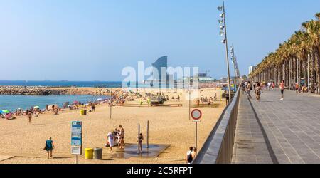 BARCELONA, SPANIEN - 12. JULI 2015: Blick auf den Barceloneta Strand von der Promenade. Barceloneta Strand - einer der beliebtesten in der Stadt. Barcelona, Spanien Stockfoto