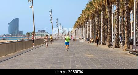 BARCELONA, SPANIEN - 12. JULI 2015: Blick auf den Barceloneta Strand von der Promenade. Barceloneta Strand - einer der beliebtesten in der Stadt. Barcelona, Spanien Stockfoto