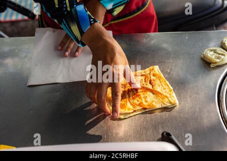Hände von Straßenhändler Kochen Thai Stil süßen Roti. Stockfoto