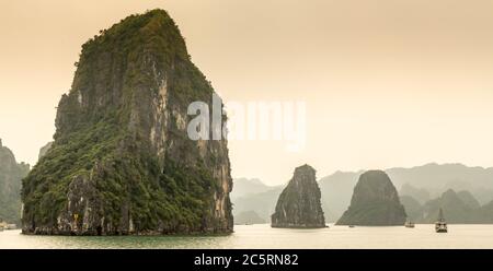 Kalksteinkarst-Inseln an einem nebligen Tag in der UNESCO-Weltkulturerbe der Ha Long Bay, in Vietnam Stockfoto