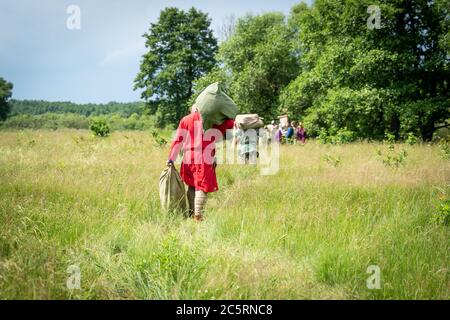 Expedition von lebenden Geschichte Liebhaber. Männer in alten Kleidern (eine Kopie der Kostüme des 9.-11. Jahrhunderts) tragen Taschen. Stockfoto