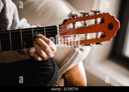 Ein junges kaukasusmädchen, das beim Gitarrenspiel übt Stockfoto