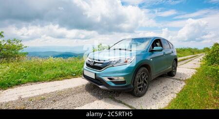 Mnt. runa, ukraine - 22. JUN 2019: Cyan honda cr-V suv auf der Bergstraße. Erkunden Sie das Wildnis-Konzept. Grat in der Ferne. Sonniges Wetter. clo Stockfoto