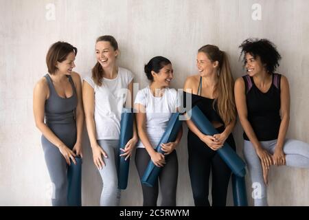 Glückliche junge gemischte Rasse weibliche Freunde genießen Kommunikation drinnen. Stockfoto