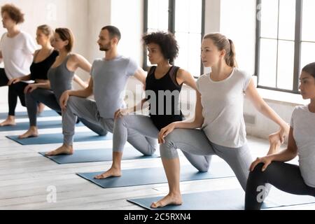 Junge starke Mischvolk Menschen üben Eka Pada Rajakapotasana. Stockfoto