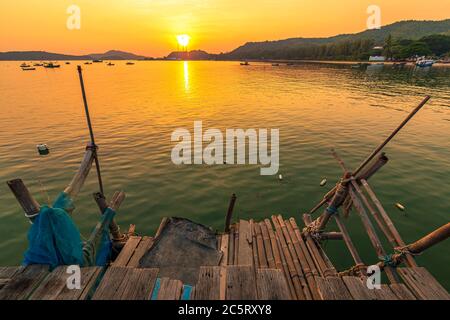 Holzdock im Meer bei Sonnenuntergang. Stockfoto