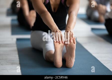 Nahaufnahme Birazialfrau berührt Füße mit Händen. Stockfoto