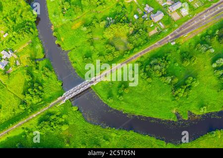 Luftbild Landschaft von gewundenen kleinen Fluss zwischen der kleinen Stadt, Bach im grünen Feld, Draufsicht Wiese Stockfoto