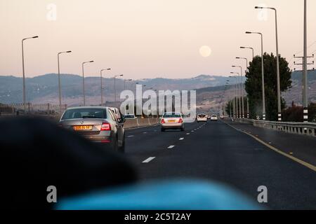 Modiin Regionalrat, Israel. Juli 2020. Ein Vollmond steigt über Israels Straße 1 Ost, von Tel Aviv nach Jerusalem. Der Vollmond des Juli ist als Buck Moon oder Hungry Ghost Moon bekannt. Quelle: Nir Alon/Alamy Live News Stockfoto