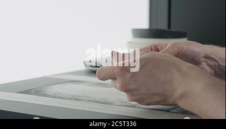 Mann Hände Sand Boden der weißen Keramik-Untertasse Stockfoto