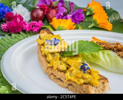 Vorspeise mit Ringelblumen und Crouton. Teller mit frischen Blumen verziert. Blumenfutter Konzept. Essbare Sommerblumen Stockfoto