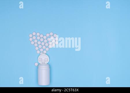 Medikamente weiße, runde herzförmige Pillen isoliert auf blauem Hintergrund. Auswahl an Medikamenten, Tabletten und Kapseln zur Behandlung von Herzerkrankungen. Kopieren Stockfoto