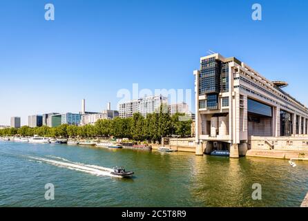 Ein Polizeiboot, das am Colbert-Gebäude, Sitz des Ministeriums für Wirtschaft und Finanzen, vorbei fährt und die seine in Paris überblickt. Stockfoto