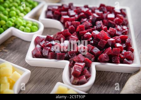 Köstliche frische Stücke von Rüben Würfel Nahaufnahme mit frischen Zwiebeln und Olivenöl auf einem Tüten Tuch auf einem rustikalen grauen Tisch. Die Rüben sind der Wurzelteil der Rübe p Stockfoto