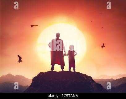 Glückliche liebevolle Familie. Vater und seine Tochter spielen draußen. Papa und sein Mädchen in einem Superhelden-Kostüme. Stockfoto